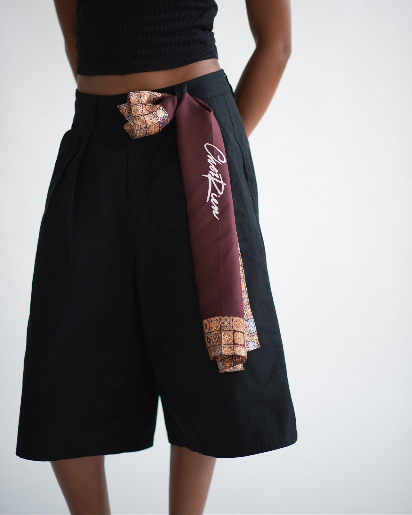 Burgundy bandana scarf with mosaic pattern border.